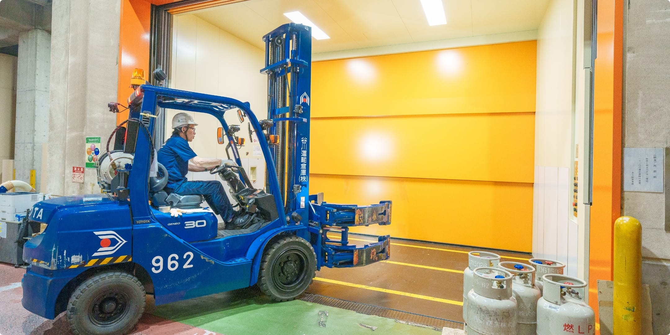 倉庫内でフォークリフトがパレットを運搬している様子