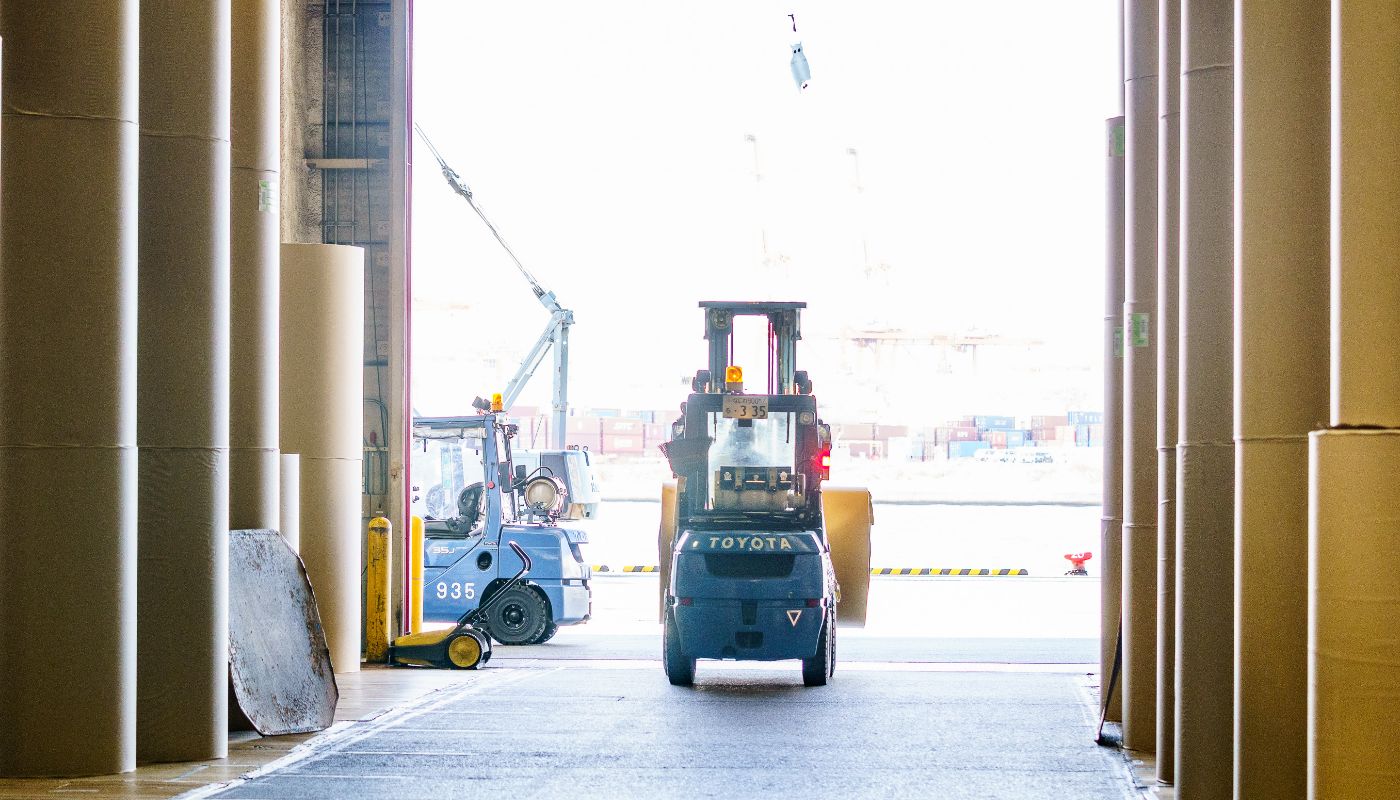 倉庫内でフォークリフトがパレットを運搬している様子